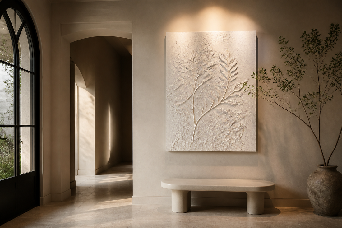 White botanical plaster relief artwork lit by grazing light in a luxury foyer